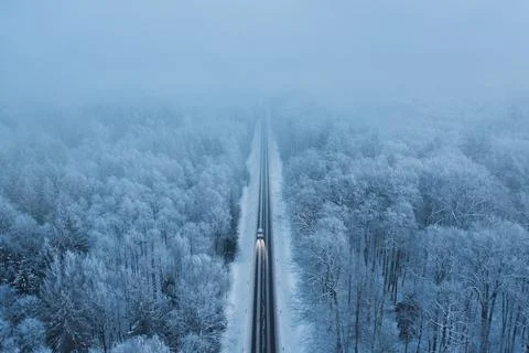 High angle view of a car on the road trough the winter forest Stock Photos