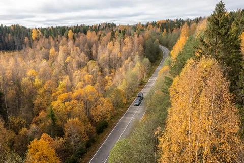 High angle view of a car with a trailer driving on a dirt road next to a Stock Photos