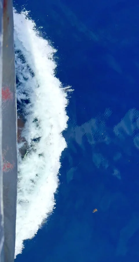 High-angle view of a cargo ship hull and foam wake in the ocean. Stock Footage 337444523