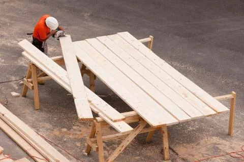 High angle view of a carpenter cutting bevels on rafters Stock Photos
