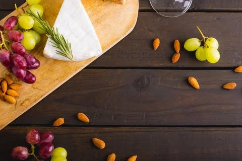 High angle view of cheese and grapes with almonds on wooden table, copy space Stock Photos