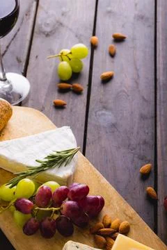 High angle view of cheese and grapes with almonds on wooden table, copy space Stock Photos