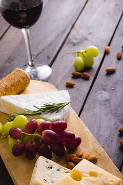 High angle view of cheese by grapes with almonds and red wine on table, copy Stock Photos