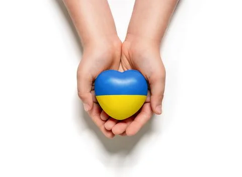 High angle view of child hands holding ukraine flag painted heart Stock Photos