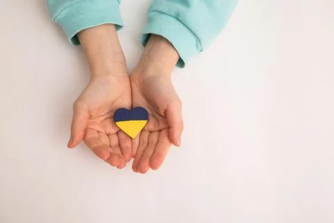High angle view of child hands holding ukraine flag painted heart Stock Photos