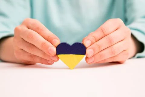 High angle view of child hands holding ukraine flag painted heart Stock Photos