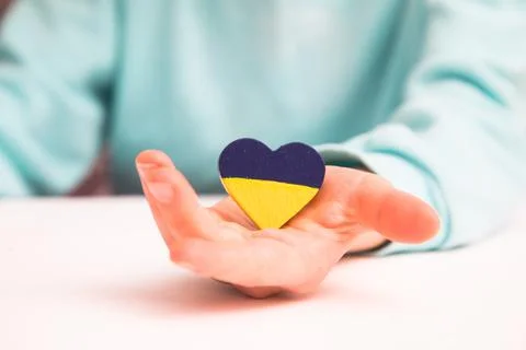 High angle view of child hands holding ukraine flag painted heart Stock Photos