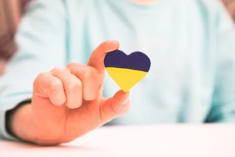 High angle view of child hands holding ukraine flag painted heart Stock Photos