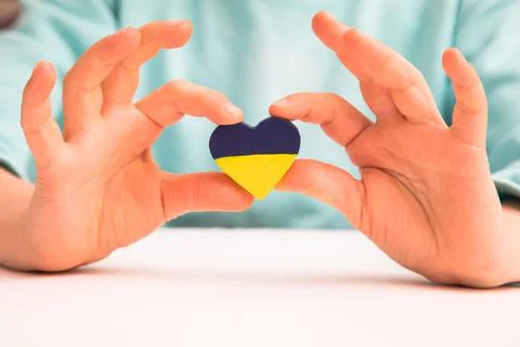 High angle view of child hands holding ukraine flag painted heart Stock Photos