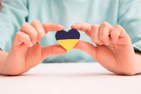 High angle view of child hands holding ukraine flag painted heart Stock Photos