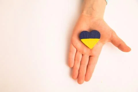High angle view of child hands holding ukraine flag painted heart Stock Photos