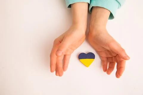 High angle view of child hands holding ukraine flag painted heart Stock Photos