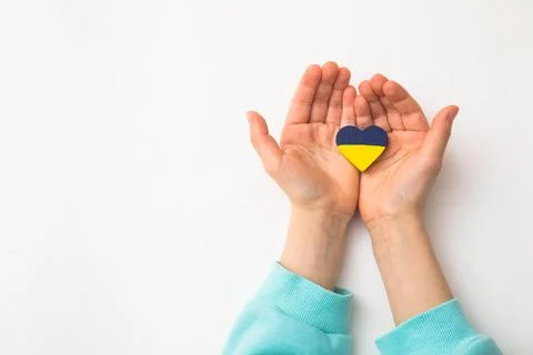 High angle view of child hands holding ukraine flag painted heart Stock Photos
