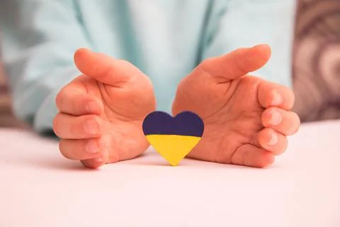 High angle view of child hands holding ukraine flag painted heart Stock Photos