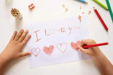 High angle view of childs hands drawing I love you sign on the paper sheet Stock Photos