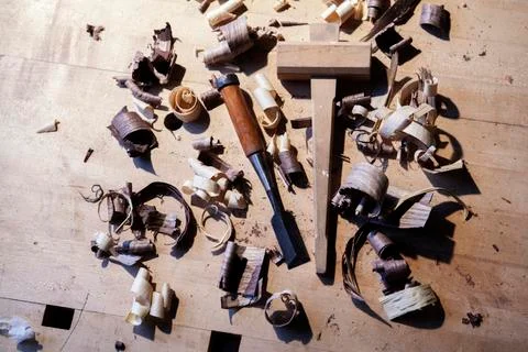 High angle view of chisel with mallet sawdust on wooden table Foto stock
