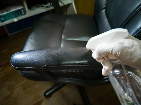 High angle view, cleaning a black work chair (wrong and dangerous method) Фото