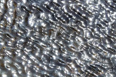 High angle view of clear and transparent water with waves reflecting sunlight. Stock Photos