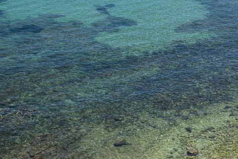 High angle view of clear sea water showing rocks and pebbles beneath the su.. Stock Photos