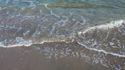 High angle view of clear turquoise ocean waves rolling onto the sandy beach. Stock Footage 337357490
