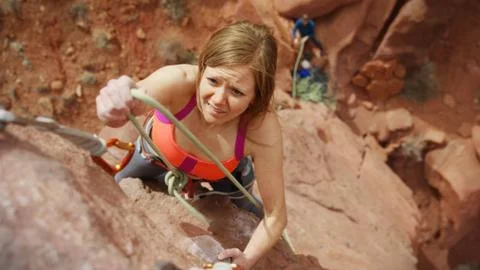 High angle view of climber tying cord on carabiner on steep rock cliff 스톡 사진