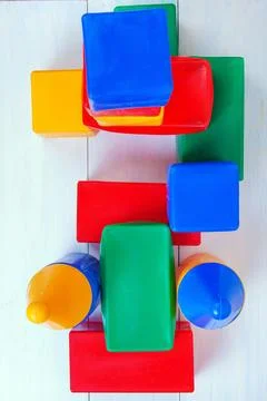 A high angle view of colorful plastic toy blocks scattered on a white surface 库存照片