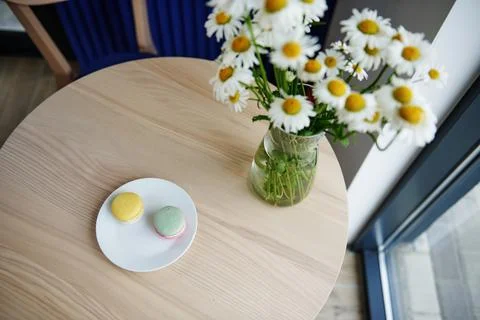 High angle view of composition with two macarons on a white plate and chamomi Foto stock