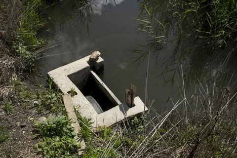 High angle view of a concrete irrigation sluice gate directing water into a.. Fotos Stock