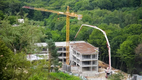 	High-angle view of a concrete pump truck and yellow tower crane Stock Footage 342763373