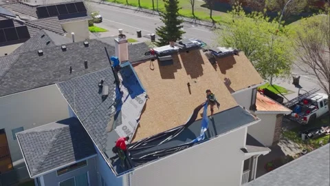 High angle view of contractors installing asphalt shingles and IKO underlayment Stock Footage 335504690