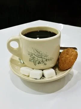 High angle view of a cup of coffee with some sugar cubes an a muffin. Food .. Stock Photos