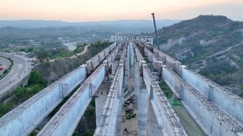 High angle view of curved unfinished highway bridge construction showing giant c Stock-Footage 335644314