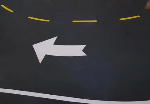 High Angle View of Curved White Traffic Arrow Symbol on the Road Foto stock