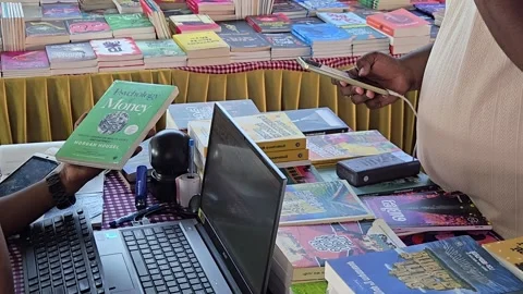 High Angle View of Customer Buying Morgan Housel Bestseller Book at Street Marke Stock Footage 336440010