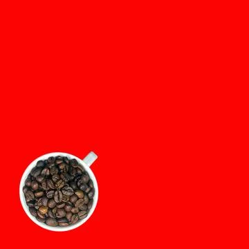 High Angle view, dark brown coffee beans in white coffee cup. Фото