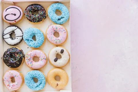 High angle view delicious donuts box pink surface Stock Photos