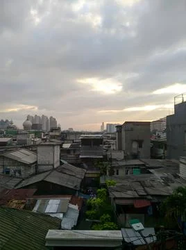 High Angle View of Dense Urban Neighborhood Rooftops under Cloudy Sunset Sky Stock Photos