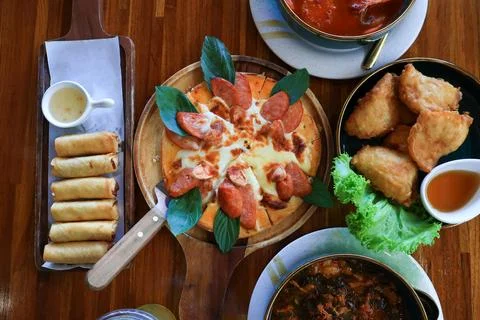 High angle view. The dining table consists of pizza, fried spring rolls, Foto stock
