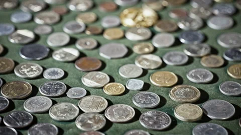 High Angle View of Diverse Collection of International Coins on Green Surface Stock Footage 339713746
