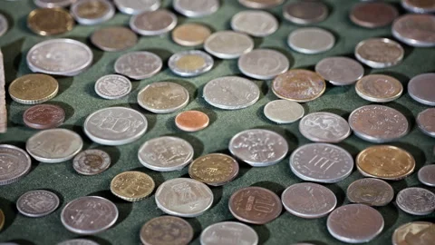 High Angle View of Diverse Collection of International Coins on Green Surface Stock Footage 344332198