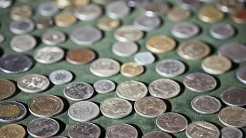 High Angle View of Diverse Collection of International Coins on Green Surface 스톡 동영상 344332201