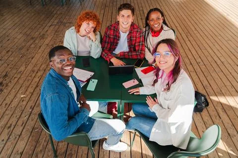 High angle view of diverse group of smiling students looking at camera whil.. Stock Photos
