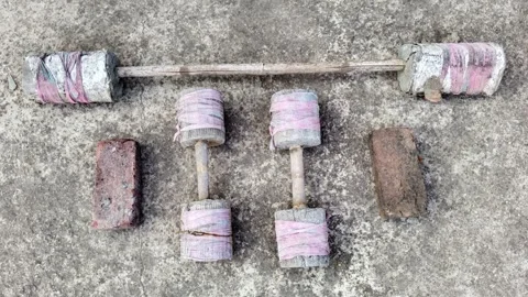 High angle view of DIY handmade concrete dumbbells and barbell on a rustic floor 스톡 동영상 328409208