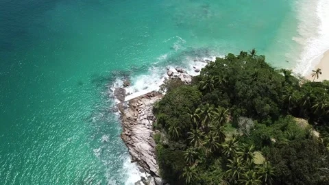 The high-angle view from the drone reveals a white beach and clear water with Stock Footage 130619815