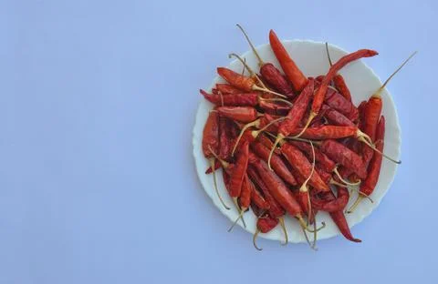 High angle view of dry red chilli peppers on the white plate  Stock Photos