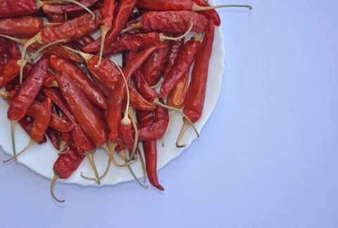 High angle view of dry red chilli peppers on the white plate  Stock Photos