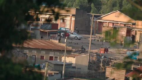 High-angle view of a dusty street with people and vehicles in a small african Stock Footage 337143609