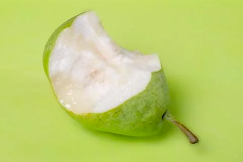 High Angle View Of Eaten Pear On Green Background Stock Photos