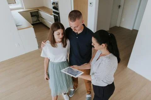 High angle view of estate agent showing young couple new apartment. Stock Photos