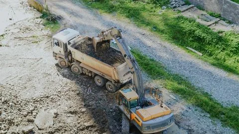 High angle view of an excavator loading dirt into a dump truck at a work site Stock Photos